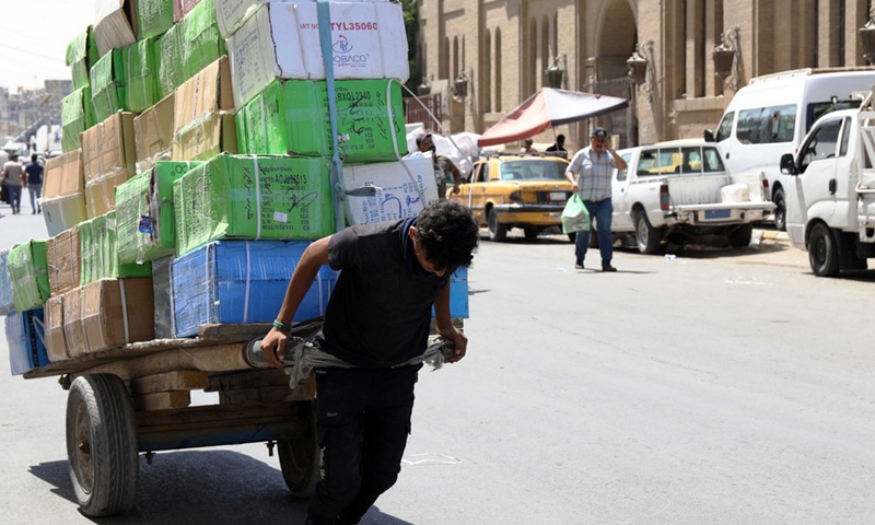 A boy pulls a cart loaded with goods in al-Rasafi Square in central Baghdad, Iraq, on Aug. 29, 2022.(Photo: Xinhua)