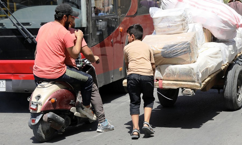 A boy pushes a cart loaded with goods on al-Rasafi Square in central Baghdad, Iraq, on Aug. 29, 2022.(Photo: Xinhua)