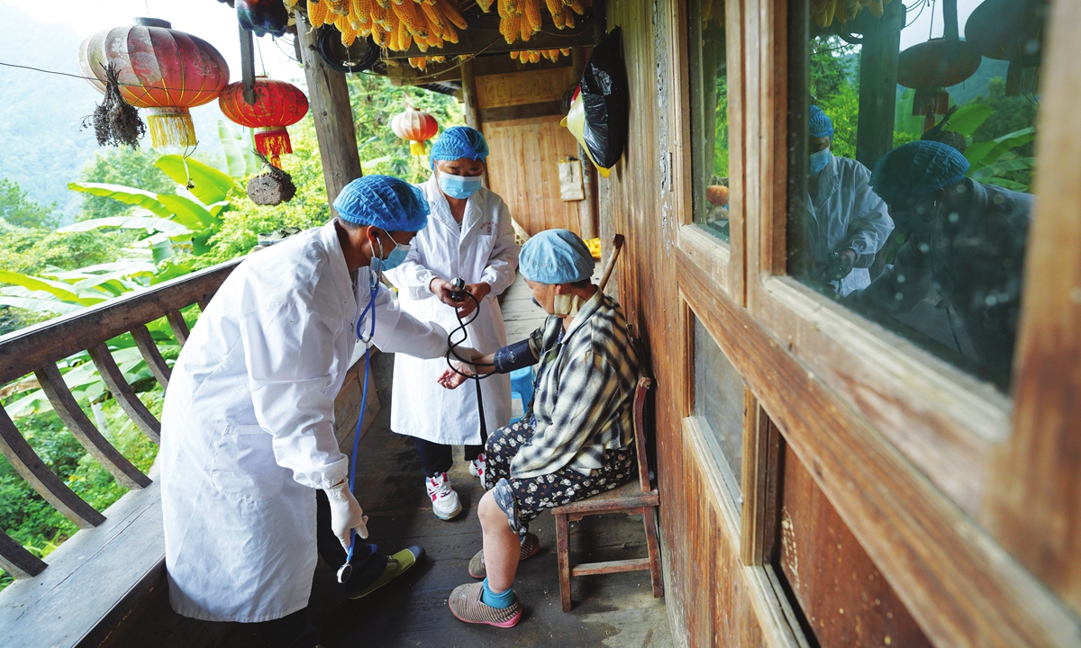 Two village doctors test blood pressure for a villager in Qiandongnan Miao and Dong Autonomous Prefecture in Southwest China's Guizhou Province on August 17, 2021. Photo: VCG