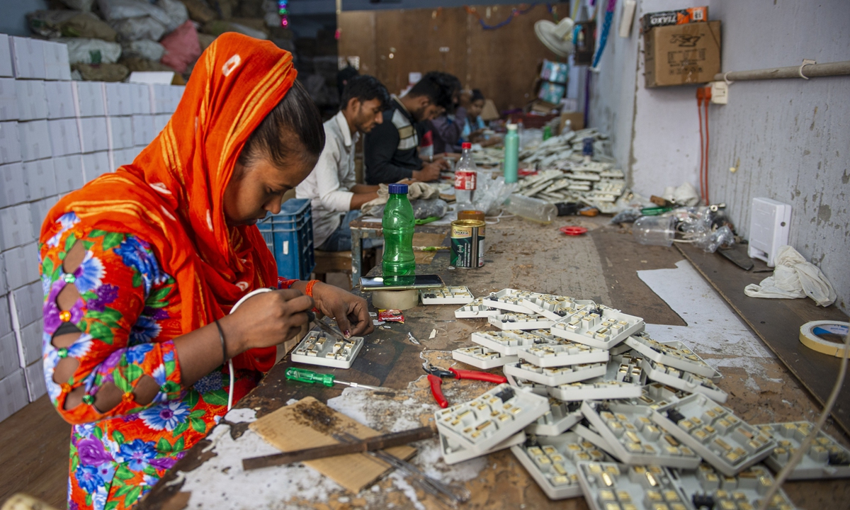 2022 年 5 月 23 日，工人们在新德里的一家工厂制作电路板。照片：VCG