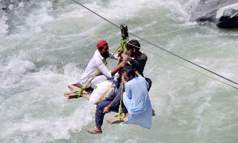 Local residents use a temporary cradle service to cross the river Swat after flash floods in Bahrain area of northwest Pakistan's Swat district on Sept. 5, 2022.(Photo: Xinhua)