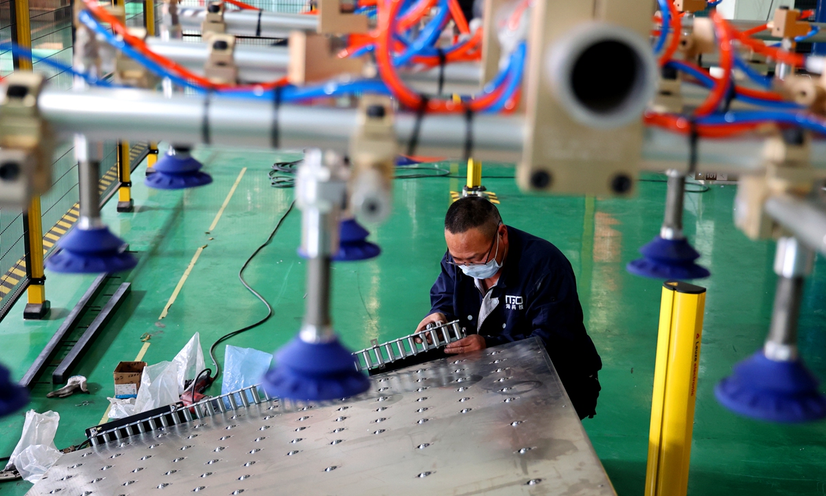 An employee processes a batch of solar heat pump equipment part in Lianyungang, East China's Jiangsu Province on April 12, 2022. Photo: VCG