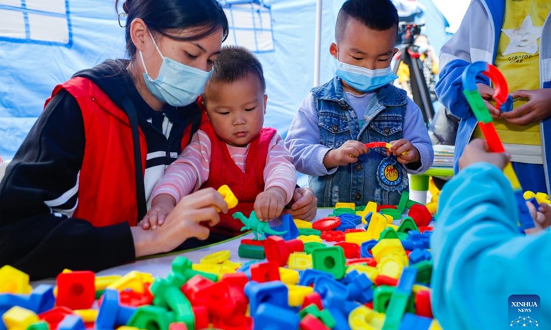 Kids play with a volunteer at a children's center at a quake relief shelter in Moxi Town of Luding County, southwest China's Sichuan Province, Sept. 7, 2022. A children's center has been built up at a quake relief shelter in Moxi Town to take care of children affected by the earthquake.(Photo: Xinhua)
