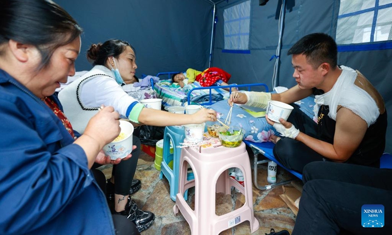 People have meal at a quake relief shelter in Moxi Town of Luding County, southwest China's Sichuan Province, Sept. 7, 2022. Free food supplies are provided for people in earthquake-hit areas in Luding.(Photo: Xinhua)