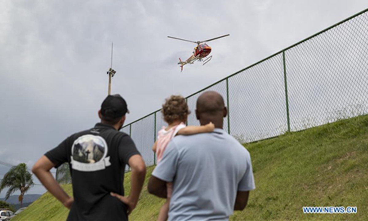People watch a rescue mission helicopter in a helping center near Brumadinho, the state of Minas Gerais, Brazil, on Jan. 26, 2019. At least 34 people were killed after a tailings dam owned by mining giant Vale collapsed Friday afternoon in Brazil's southeastern state of Minas Gerais. (Xinhua/Li Ming)