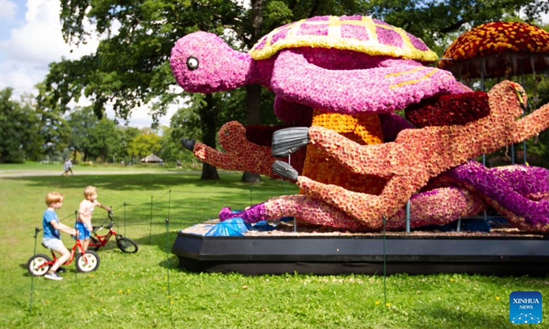 Children view a flower float of dahlia at the Keukenhof Castle in Lisse, the Netherlands, on Sept. 11, 2022.Photo:Xinhua