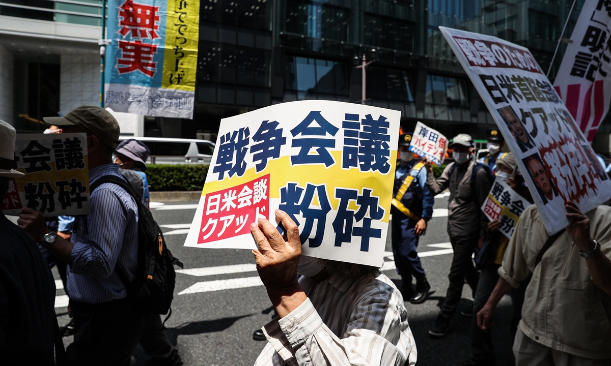 People hold signs and chant slogans during a march to protest against the US-led Quad summit on May 24, 2022 in Tokyo. Photo: VCG