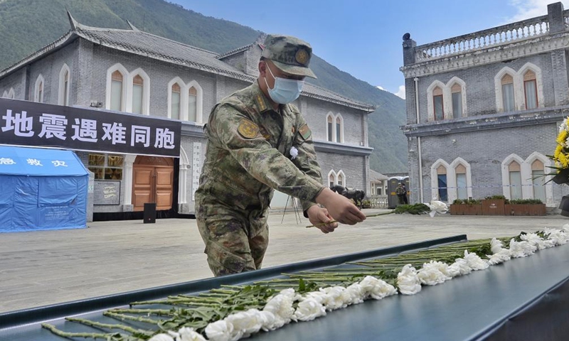 A soldier lays a flower to mourn for the victims of the earthquake during a memorial service in Moxi Town of Luding County, southwest China's Sichuan Province, Sept. 12, 2022.Photo:Xinhua
