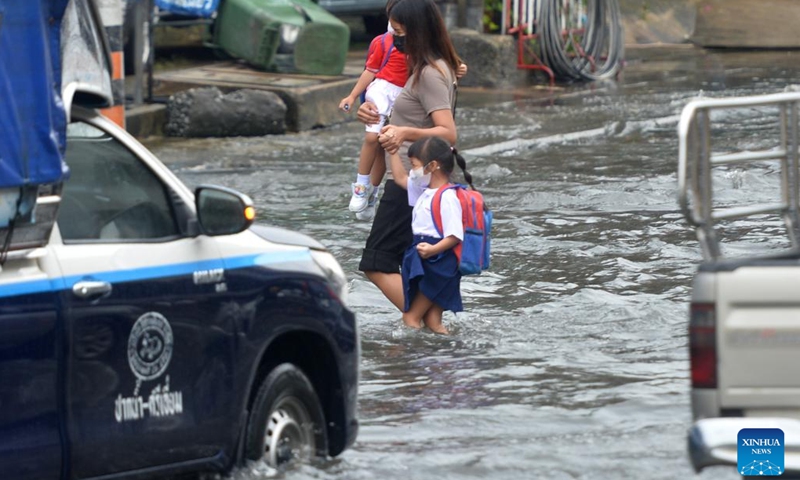 People wade through floodwater in Bangkok, Thailand, on Sept. 13, 2022. The Bangkok Metropolitan Administration (BMA) on Tuesday issued a warning of moderate to heavy rain and potential floods from 4 p.m. to 11 p.m local time in the Thai capital's 12 districts. This came after several parts of the city had been inundated after heavy monsoon rains in the last several days.(Photo: Xinhua)