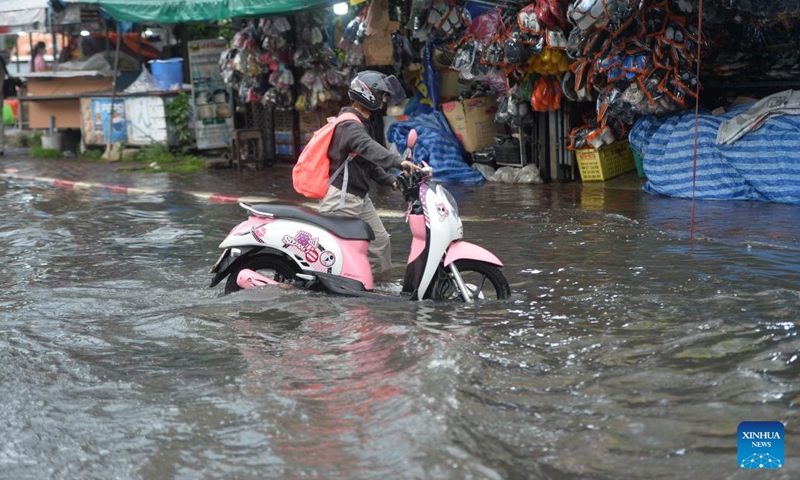 A person with a motorcycle wades through floodwater in Bangkok, Thailand, on Sept. 13, 2022. The Bangkok Metropolitan Administration (BMA) on Tuesday issued a warning of moderate to heavy rain and potential floods from 4 p.m. to 11 p.m local time in the Thai capital's 12 districts. This came after several parts of the city had been inundated after heavy monsoon rains in the last several days.(Photo: Xinhua)