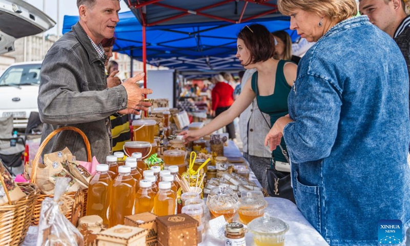 A stall owner introduces honey products to customers at a food fair in Vladivostok, Russia, Sept. 14, 2022. (Photo: Xinhua)