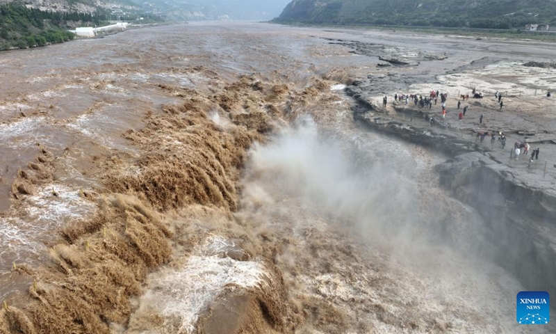 Aerial photo taken on Sept. 15, 2022 shows tourists viewing the scenery of the Hukou Waterfall on the Yellow River in northwest China's Shaanxi Province. Hukou waterfall is witnessing an increasing water flow lately.(Photo: Xinhua)