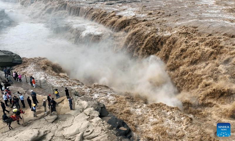 Aerial photo taken on Sept. 15, 2022 shows tourists viewing the scenery of the Hukou Waterfall on the Yellow River in northwest China's Shaanxi Province. Hukou waterfall is witnessing an increasing water flow lately.(Photo: Xinhua)