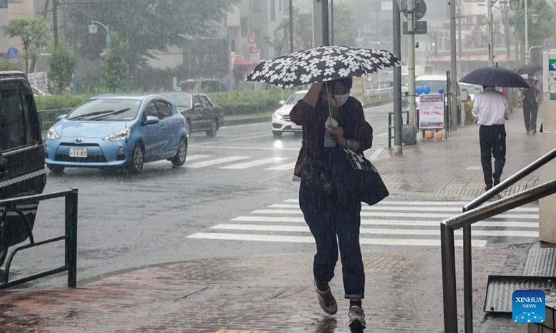Pedestrians walk in the rain along a street in Tokyo, Japan, Sept. 19, 2022. Two people were reported dead and another missing on Monday after powerful typhoon Nanmadol landed in Japan's southwestern region of Kyushu, bringing rain and gales, local media reported. (Xinhua/Zhang Xiaoyu)