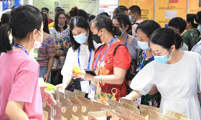 Visitors buy commodities from Laos during the 19th China-ASEAN Expo in Nanning, capital of south China's Guangxi Zhuang Autonomous Region, Sept. 18, 2022. The 19th China-ASEAN Expo, scheduled for Sept. 16 to 19 in Nanning, has attracted a total of 1,653 enterprises to its offline event. A wide range of featured commodities from ASEAN countries have caught visitors' eyes during the expo. (Xinhua/Zhou Hua)

