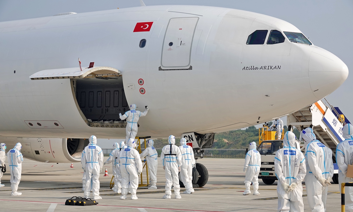 Airport staffers wearing protective suits serve a cargo plane from Istanbul at Yantai Penglai International Airport in Yantai, East China's Shandong Province on September 18, 2022. The arrival of the plane marks the official opening of an intercontinental cargo route linking Yantai and Istanbul, Turkey. There are two flights a week, each carrying 60 tons of goods. Photo: VCG
