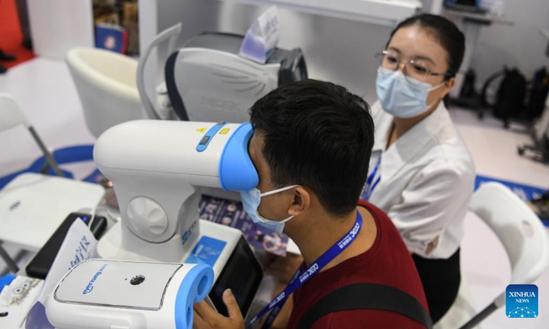 A visitor tries a vision tester during the 19th China-ASEAN Expo in Nanning, capital of south China's Guangxi Zhuang Autonomous Region, Sept. 17, 2022.Photo:Xinhua