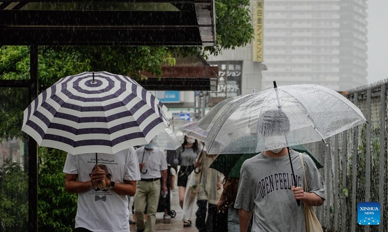Pedestrians walk in the rain along a street in Tokyo, Japan, Sept. 19, 2022. Two people were reported dead and another missing on Monday after powerful typhoon Nanmadol landed in Japan's southwestern region of Kyushu, bringing rain and gales, local media reported. (Xinhua/Zhang Xiaoyu)