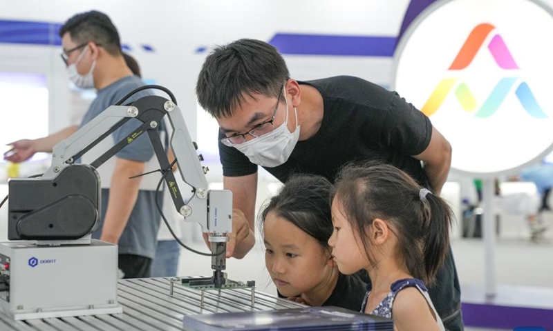 Children look at an intelligent mechanical arm at the main venue of 2022 national mass entrepreneurship and innovation week in Hefei, capital of east China's Anhui Province, Sept. 17, 2022.Photo:Xinhua