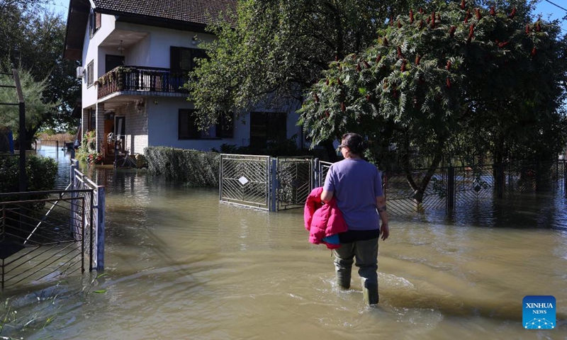 A woman wades through flood water due to heavy rainfall in Brodarci in central Croatia, on Sept. 18, 2022. (Kristina Stedul Fabac/PIXSELL via Xinhua)