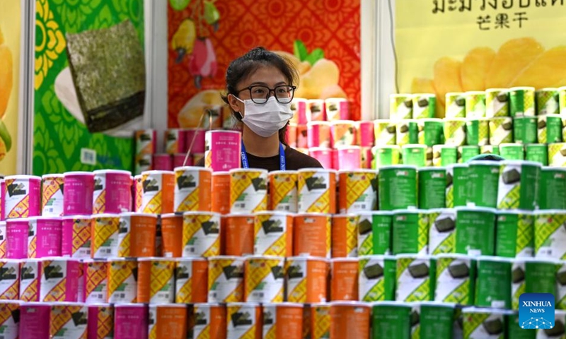 An exhibitor presents dried mango from Thailand during the 19th China-ASEAN Expo in Nanning, capital of south China's Guangxi Zhuang Autonomous Region, Sept. 18, 2022. The 19th China-ASEAN Expo, scheduled for Sept. 16 to 19 in Nanning, has attracted a total of 1,653 enterprises to its offline event. A wide range of featured commodities from ASEAN countries have caught visitors' eyes during the expo. (Xinhua/Zhang Ailin)

