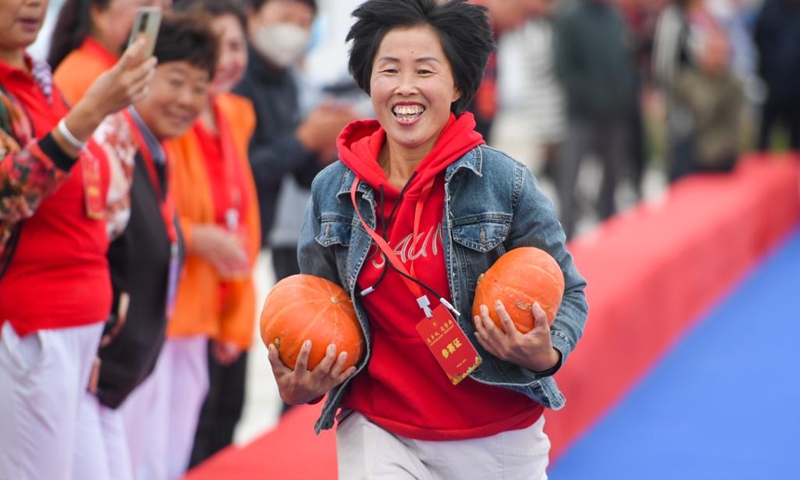 A woman takes part in a game to celebrate the upcoming Chinese farmers' harvest festival in Hohhot, north China's Inner Mongolia Autonomous Region, Sept. 19, 2022. Initiated in 2018, the Chinese farmers' harvest festival coincides with the autumnal equinox each year, which is one of the 24 solar terms of the Chinese lunar calendar and usually falls between Sept. 22 and 24 during the country's agricultural harvest season.(Photo: Xinhua)