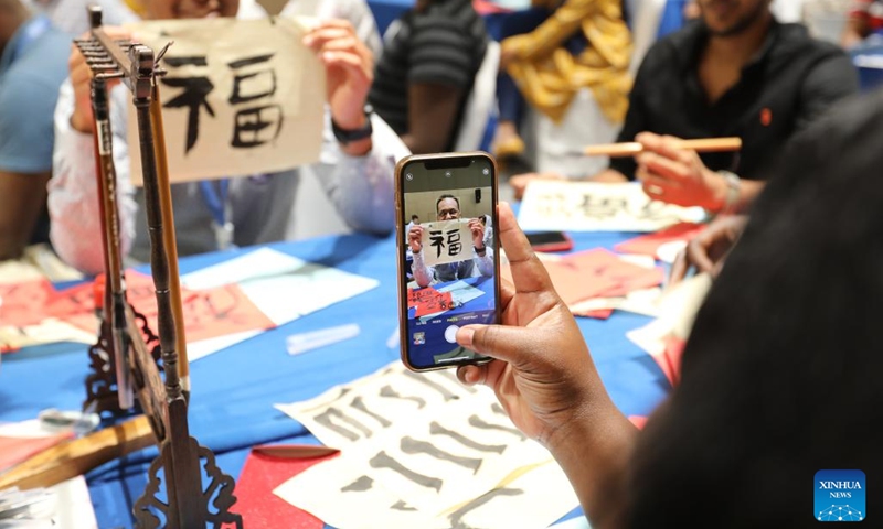 A trainee poses for a photo with his calligraphy work during a Chinese culture program in Djibouti City, capital of Djibouti on Sept. 18, 2022. A Chinese culture program was held here Sunday for young entrepreneurs from Djibouti, Ethiopia, Kenya and Uganda.(Photo: Xinhua)