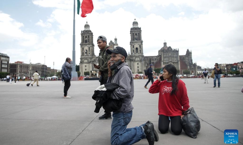 People make calls after hearing an earthquake alarm in the Zocalo Square in Mexico City, Mexico, on Sept. 19, 2022.(Photo: Xinhua)