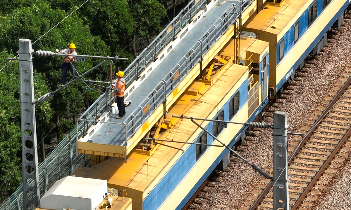Workers carry out an overhaul of the electric cables for a rail line at the Baozhuang Railway Station in Lianyungang, East China's Jiangsu Province, on September 21, 2022. The railway department is preparing for the upcoming National Day holiday rail travel boom by ensuring the safe operation of electrified equipment. Photo: VCG