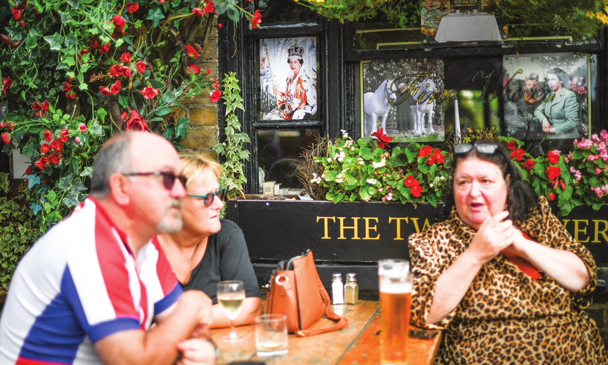 Customers sit at a table at a pub in London on September 12, 2022, following the death of Queen Elizabeth II on September 8. Photos: AFP