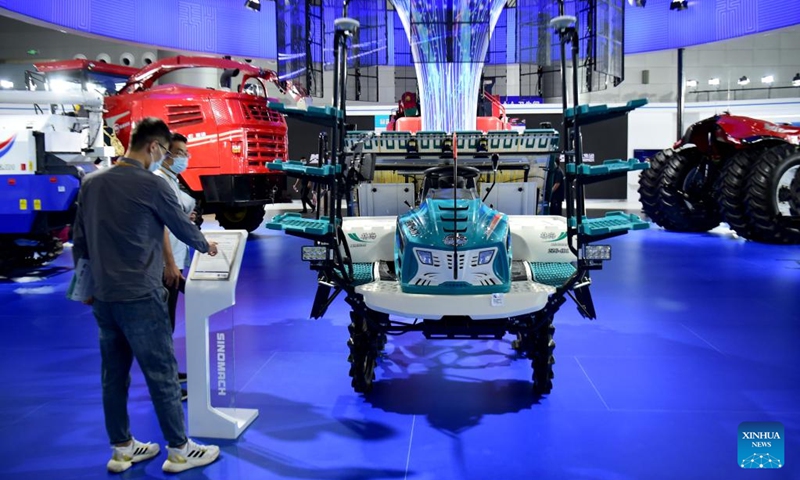 People look at a high performance rice transplanter at the 2022 World Manufacturing Convention in Hefei, east China's Anhui Province, Sept. 20, 2022. The 2022 World Manufacturing Convention opened Tuesday in east China, highlighting the latest products, technologies and applications in the manufacturing sector.(Photo: Xinhua)