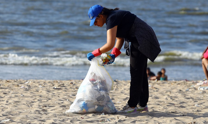 A woman collects waste from the beach in Alexandria, Egypt, Aug. 13, 2022.(Photo: Xinhua)