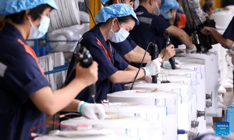 Workers operate at the production line of electric water heaters at a company in Foshan, south China's Guangdong Province, Sept. 30, 2022. (Xinhua/Huang Guobao)