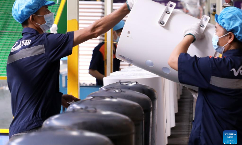Workers operate at the production line of electric water heaters at a company in Foshan, south China's Guangdong Province, Sept. 30, 2022. (Xinhua/Huang Guobao)