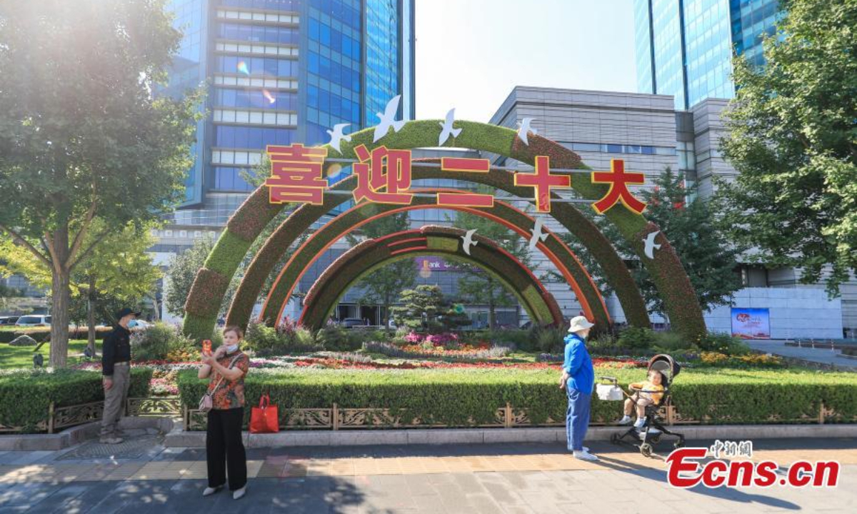 People pose for photos in front of a flower terrace along the Chang'an Avenue in Beijing, Sep 22, 2022. Photo: China News Service