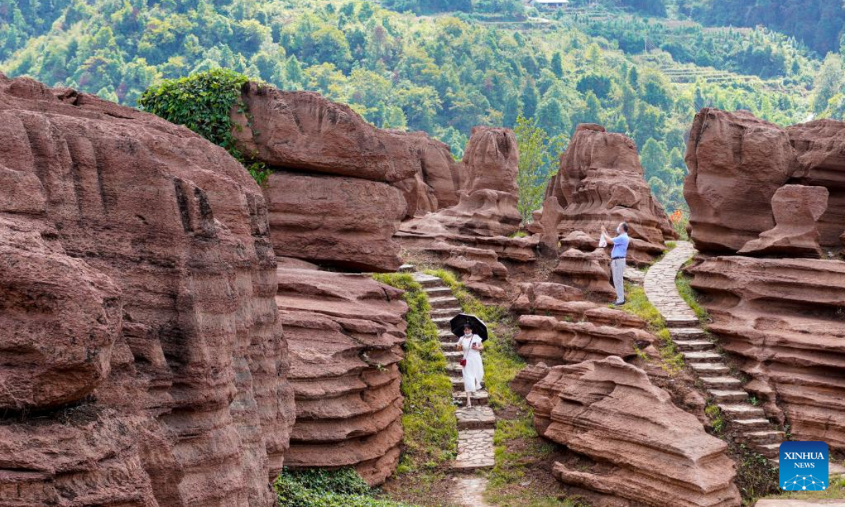 Tourists visit a red stone forest geopark in Youyang Tujia and Miao Autonomous County, southwest China's Chongqing Municipality, Oct. 3, 2022. The Youyang red stone forest geopark, which has the karst landform, opened to the public during the National Day holiday. Photo:Xinhua