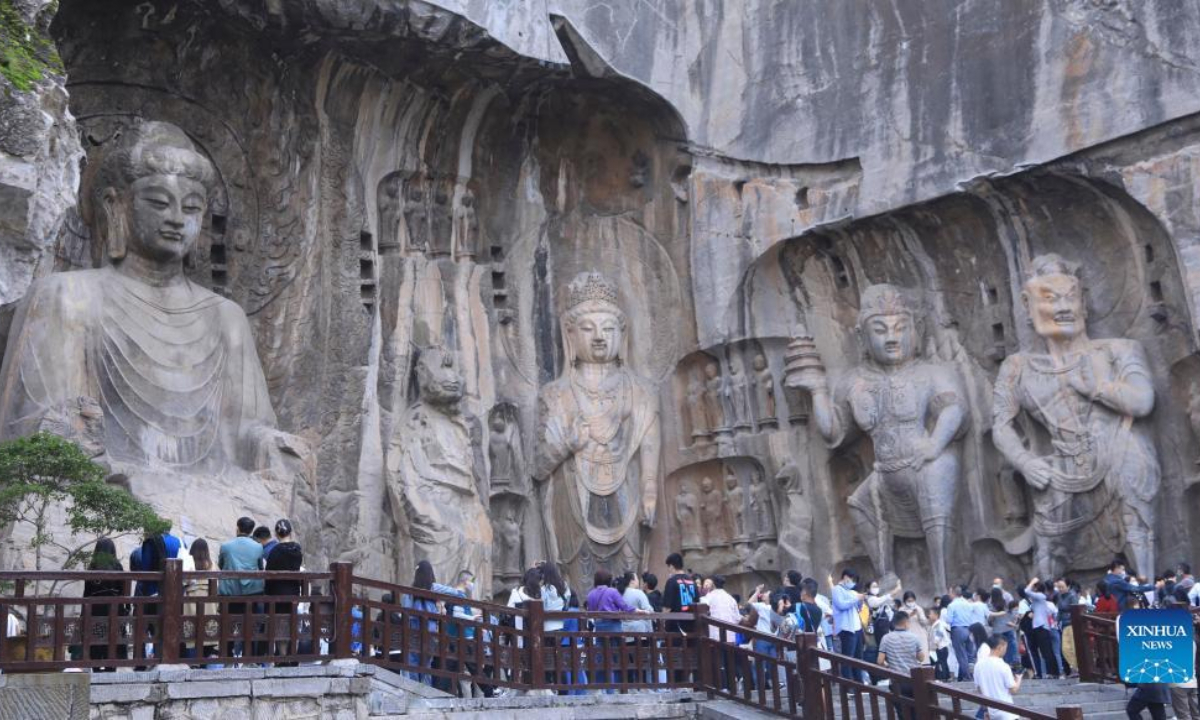 Tourists visit the Longmen Grottoes during the National Day holiday in Luoyang, central China's Henan Province, Oct. 3, 2022. (Photo by Jia Fangwen/Xinhua)