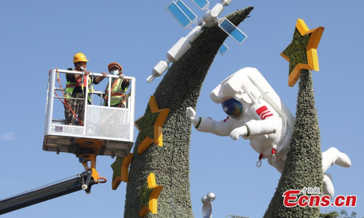 Workers set up a flower terrace at the corner of the Dongdan intersection in Beijing to celebrate the National Day, Sep 22, 2022. Photo: China News Service