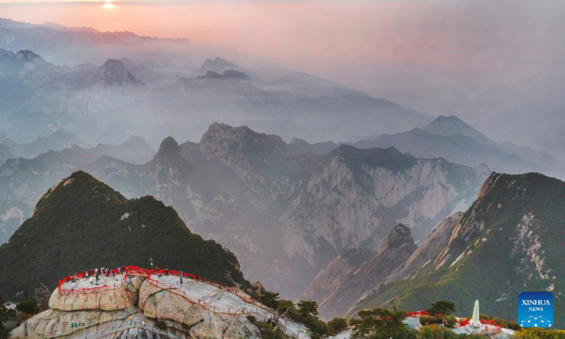 Aerial photo taken on Sept. 25, 2022 shows people visiting Mount Huashan at sunset in northwest China's Shaanxi Province. (Xinhua/Tao Ming)