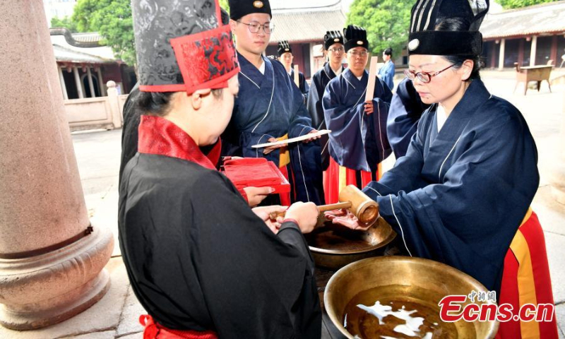 2022年9月28日，在中国东部福州市孔庙举行的孔子诞辰2573周年仪式上，身着传统服饰的参与者表演。（图片：中新社/吕明）