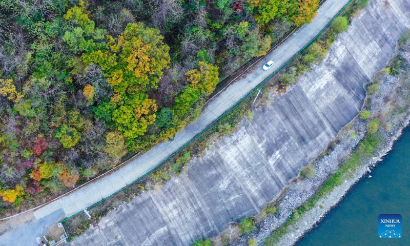 A car is seen driving along the road beside the Hongshi National Forest Park in Jilin City, northeast China's Jilin Province, Oct. 5, 2022. (Xinhua/Yan Linyun)