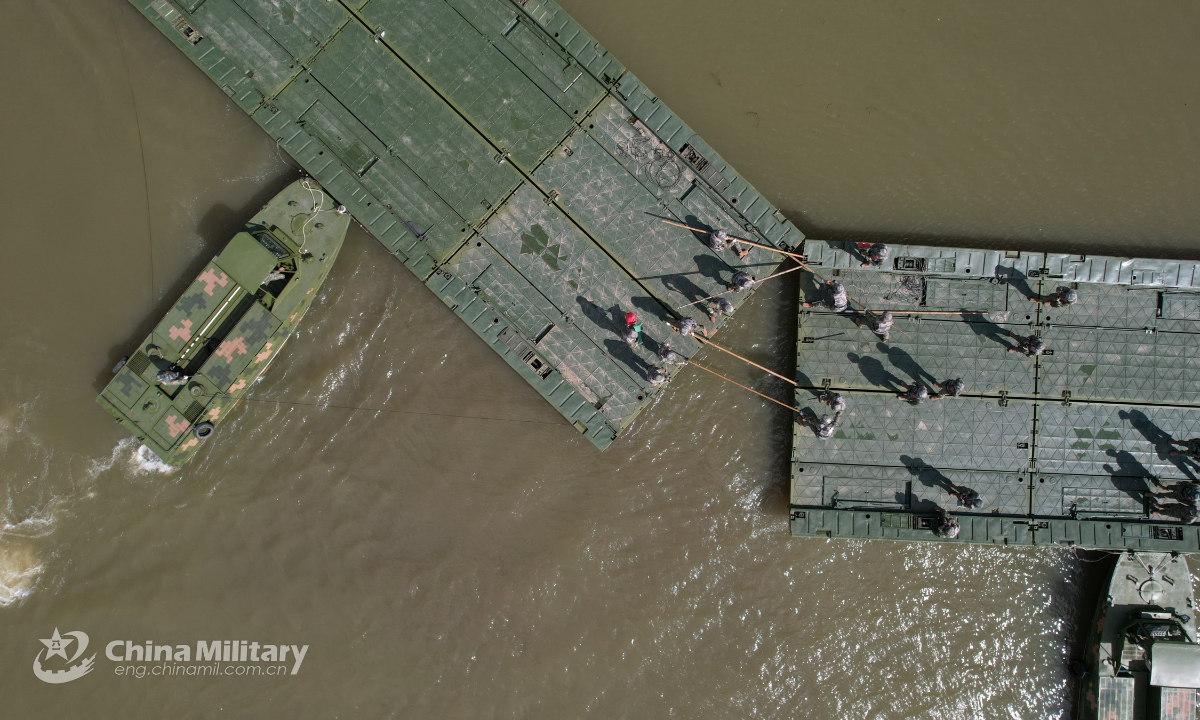 Soldiers assigned to a brigade under the PLA 78th Group Army connect two pontoons together under the help of the propulsion boats during an integrated support exercise on September 7, 2022. Photo: China Military