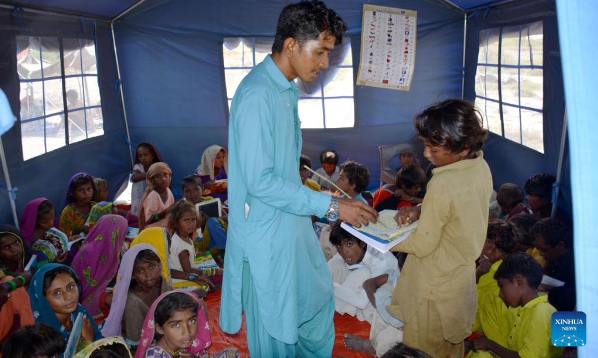 Flood-affected children attend a class in a makeshift shelter built with tents donated by China in flood relief aid in Matli town of Badin District in southern Pakistan's Sindh province on Sep 29, 2022. Photo:Xinhua