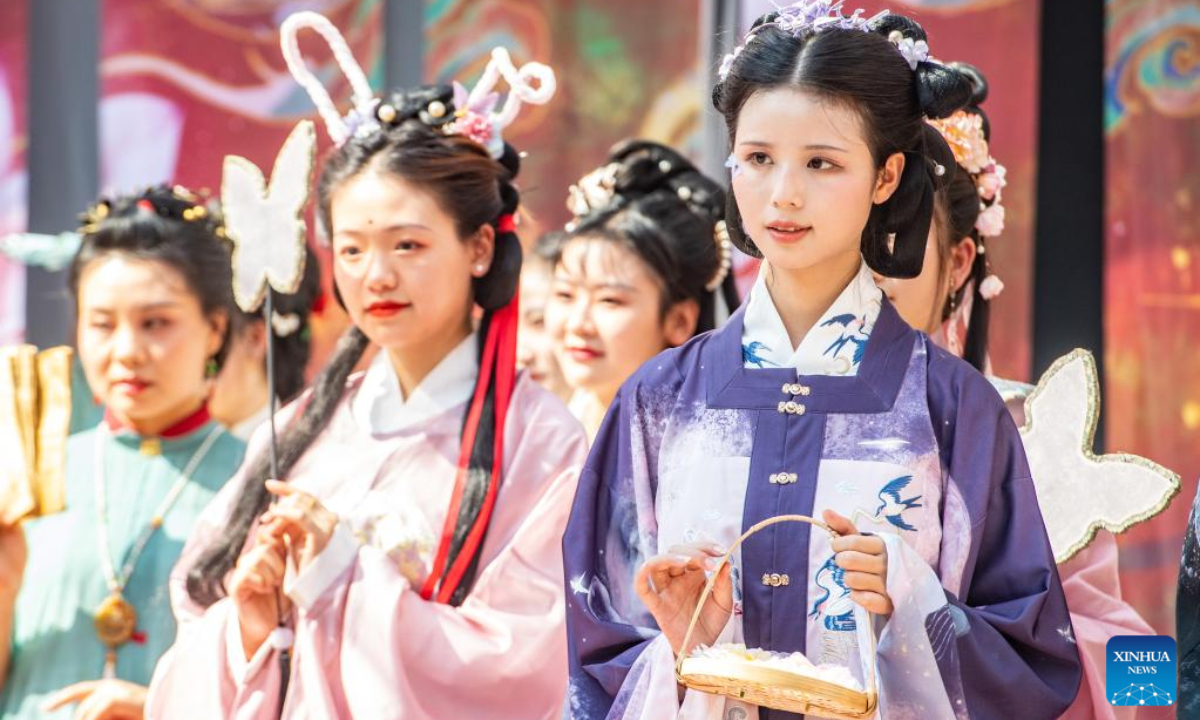 Women present Hanfu, a type of traditional Chinese garment, in Ciqikou ancient town, southwest China's Chongqing Municipality, Oct. 2, 2022. During the National Day holiday, the scenic area Ciqikou has conducted various activities themed with traditional Chinese culture to attract tourists. (Xinhua/Tang Yi)