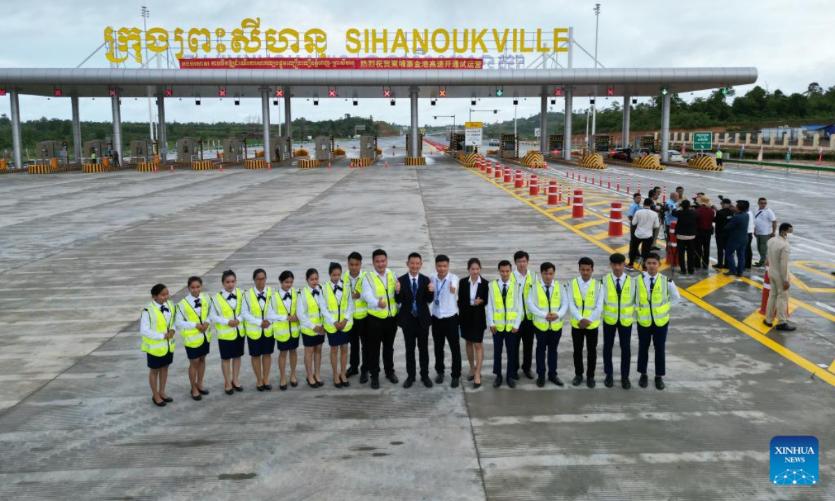 Staff members of the Phnom Penh-Sihanoukville Expressway pose for a photo in front of a toll station in Sihanoukville, Cambodia, Oct 1, 2022. The Chinese-invested Phnom Penh-Sihanoukville Expressway (PPSHV Expressway) in Cambodia was opened to the public on Saturday for a month's trial use for free to attract motorists driving on the first-ever expressway in the Southeast Asian nation. Photo:Xinhua