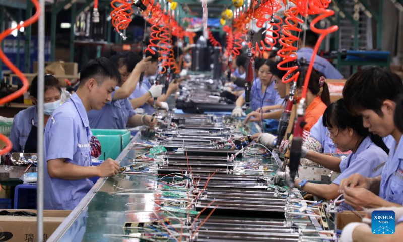 Workers operate at the production line of electric heaters at a company in Foshan, south China's Guangdong Province, Sept. 29, 2022. (Xinhua/Huang Guobao)