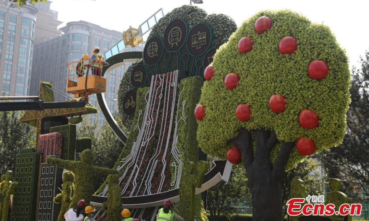 Workers set up a flower terrace at the corner of the Dongdan intersection in Beijing to celebrate the National Day, Sep 22, 2022. Photo: China News Service