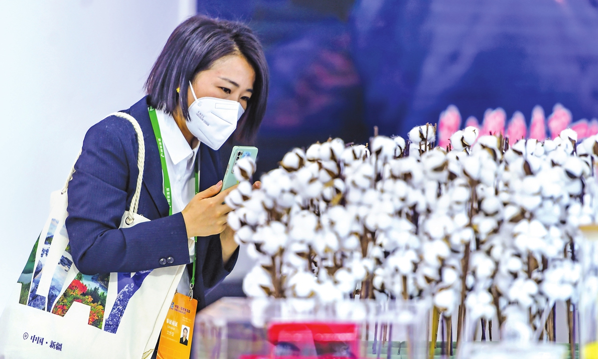 A visitor takes photo of the white cotton balls picked from fields in Urumqi, Northwest China's Xinjiang Uygur Autonomous Region at the 7th China-Eurasia Expo on September 20, 2022. Photo: VCG