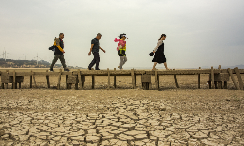 Tourists walk on a stone bridge built in the Ming Dynasty (1368-1644) on dried-out Poyang Lake in Duchang county, East China's Jiangxi Province, on September 21, 2022. Photo: VCG