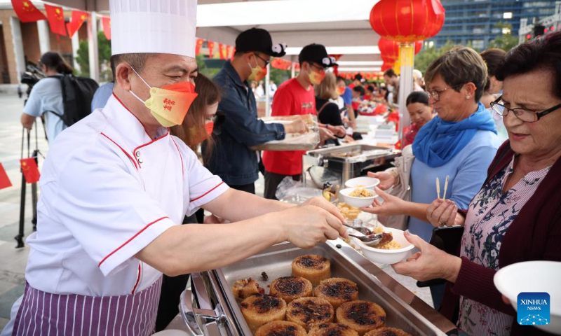 People try Chinese food during the Chinese Culture Week 2022 in Tirana, Albania, Sept. 30, 2022. A series of Chinese cultural activities have been held in Albania's capital city Tirana since Sept. 26, including a Chinese culture-themed gala at the city center Friday evening. (Photo by Gent Onuzi/Xinhua)